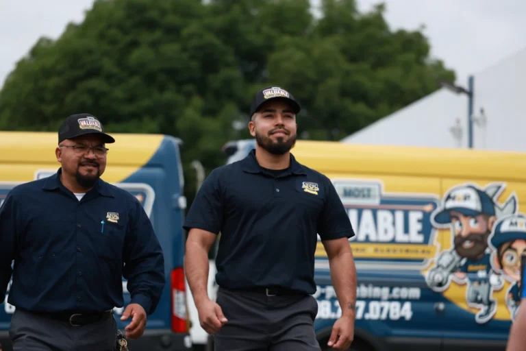 Two uniformed workers walk in front of a branded service van, specializing in gas line installation, with trees and a building in the background.