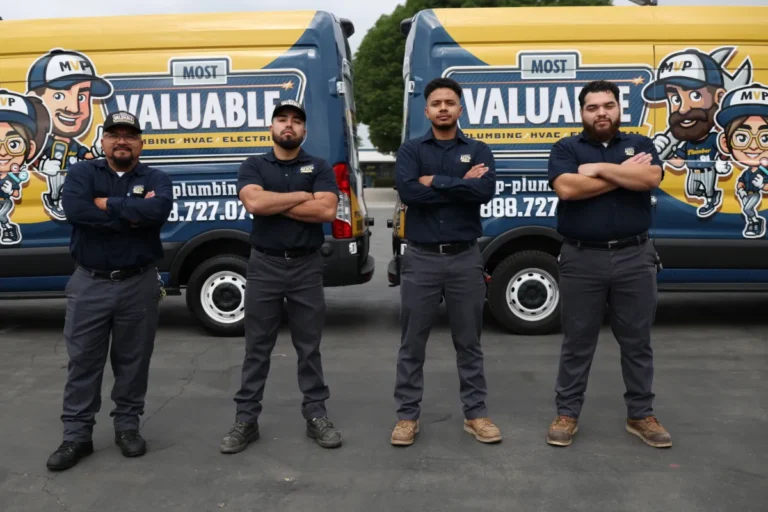 Four men in matching uniforms stand with arms crossed in front of branded company vans featuring cartoon graphics and "Most Valuable" on the vehicles, ready to provide expert leak detection services.