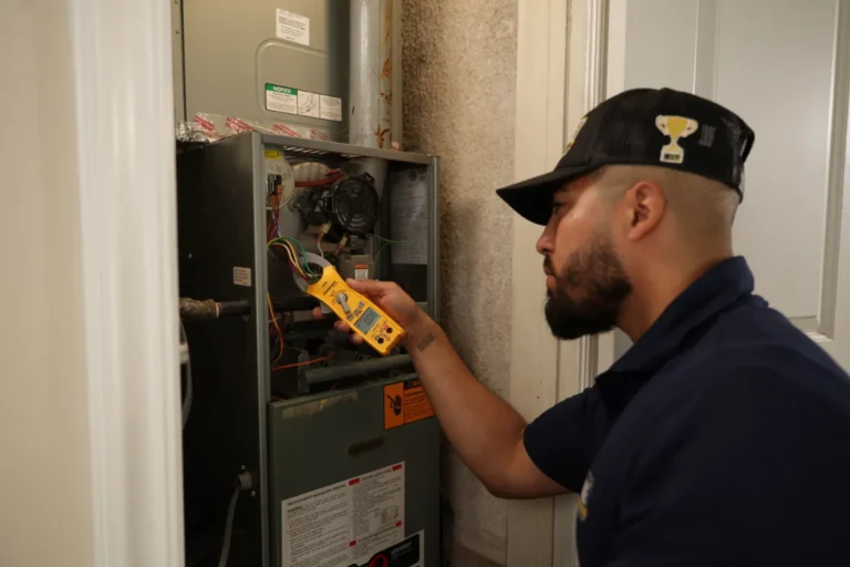 A technician uses a yellow multimeter to check electrical components inside an open HVAC unit in a residential setting.